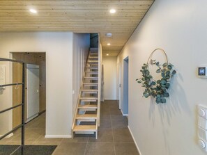 A modern interior with a wooden staircase, a wall-mounted plant, and a thermostat. - Villa aava by Interhome (Ylläsjärvi)
