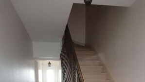 A staircase with a checkered floor leading to a door at the top.