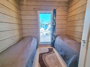 A narrow room with wooden walls, a window, and a door. - Vacation home Loimu by Interhome (Enontekiö)