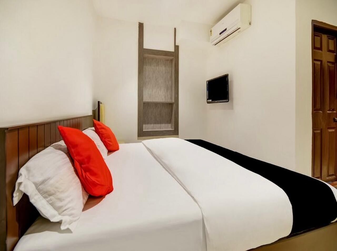 A hotel room with a bed, a TV, and a wardrobe.