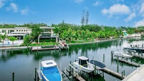 A marina with boats docked, a clear sky, and modern buildings in the background. - Luxury 2 Bed 2 Bath Waterfront Condo with Patio Sunsets Gym and Parking (Sarasota)