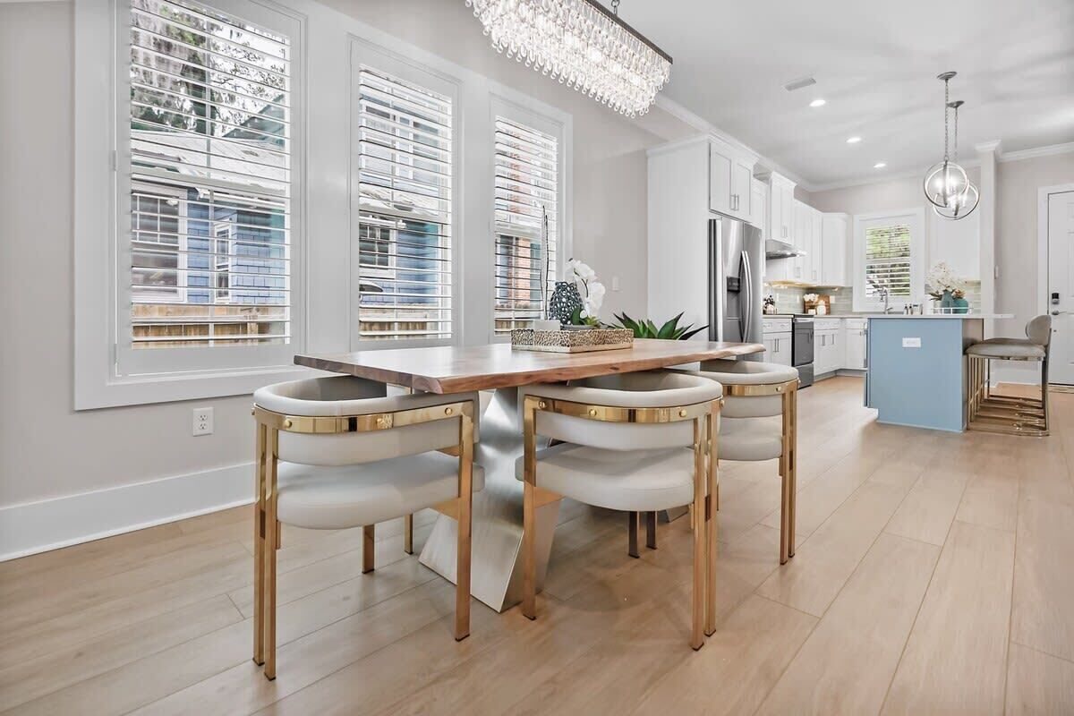 A modern kitchen with a central island, white cabinetry, and a chandelier.