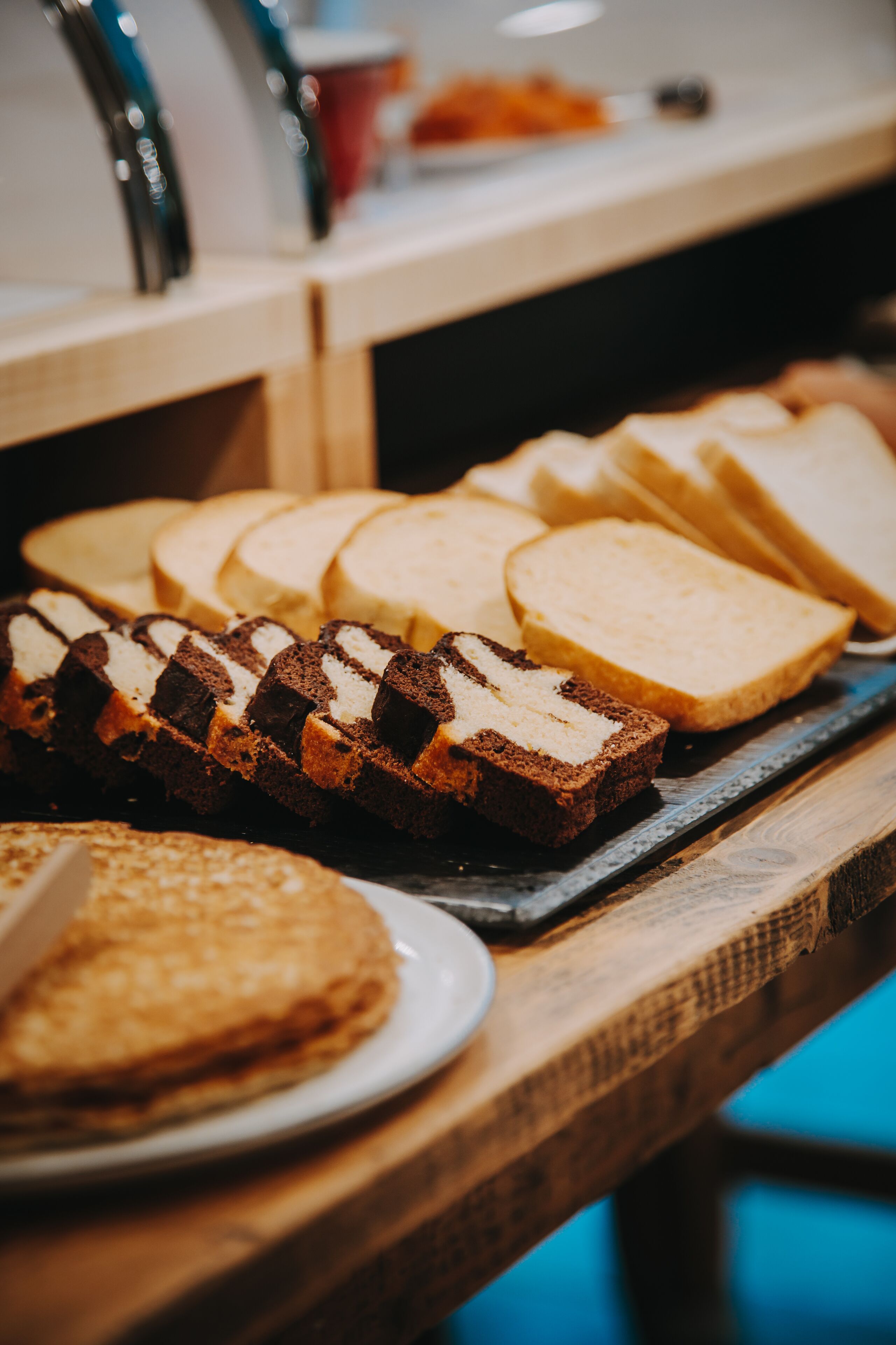 A variety of breads and pastries on a wooden counter.