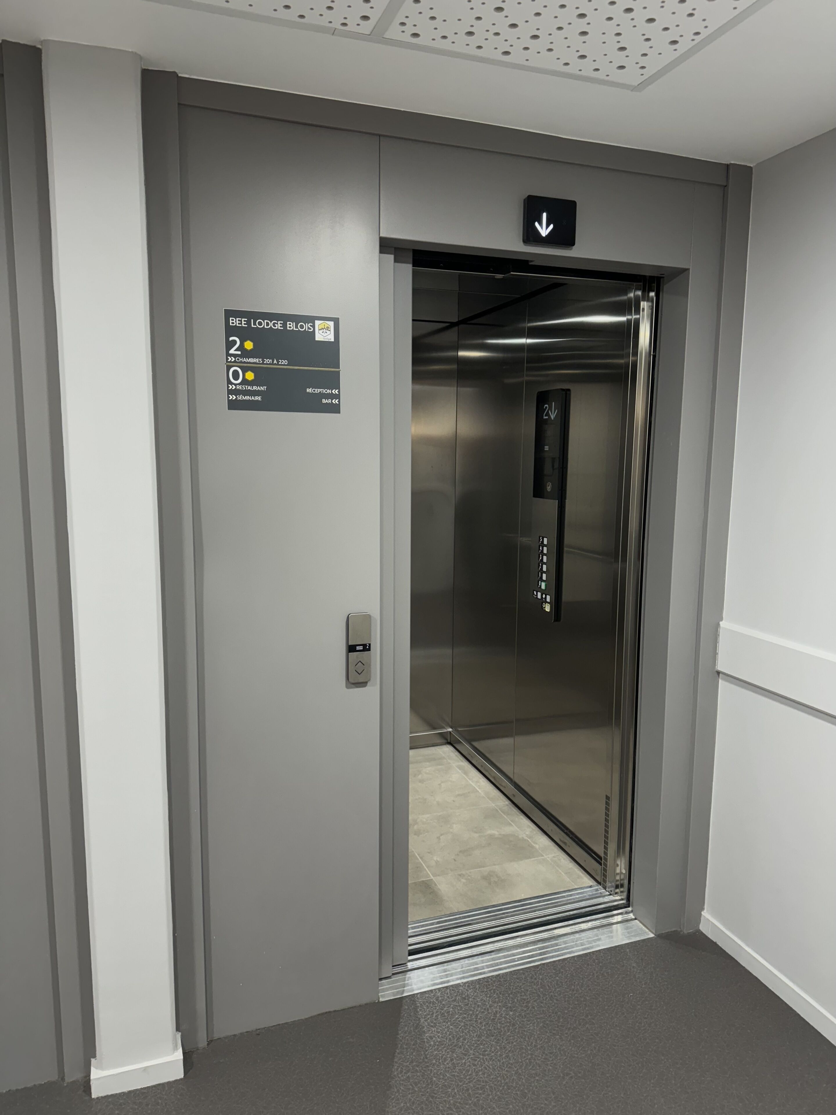 An elevator with a sign indicating the floor level and directions to various hotel amenities.