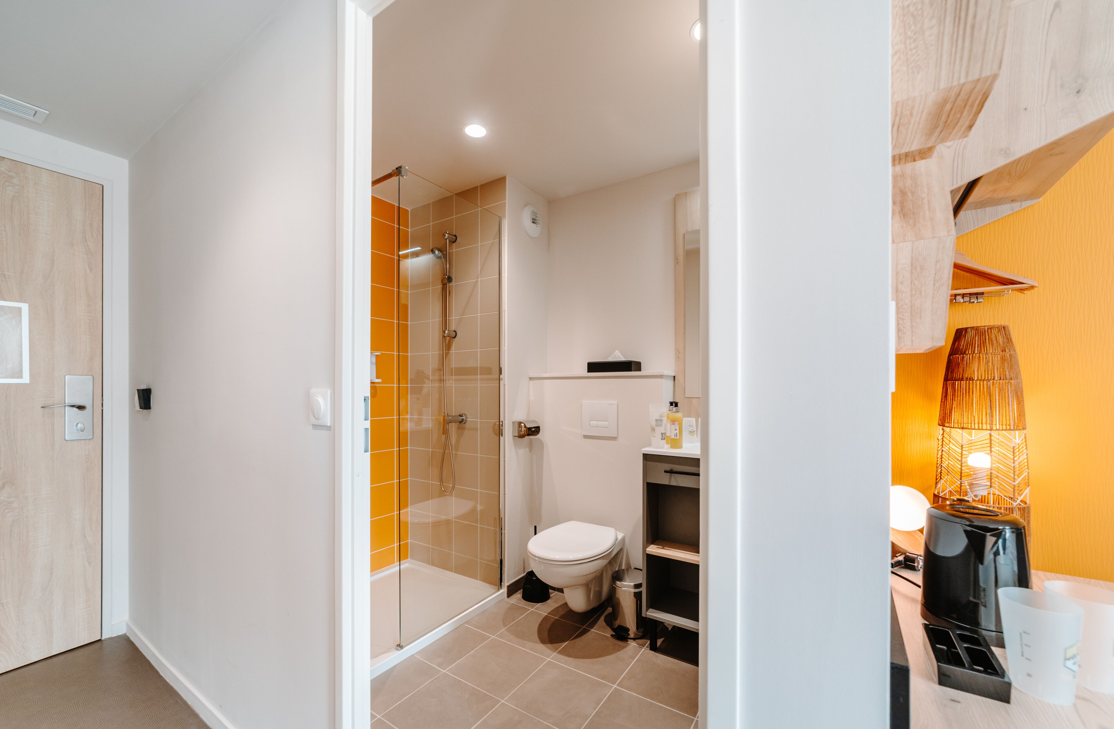 Une salle de bain moderne avec une douche à parois de verre, des toilettes et un espace lavabo.