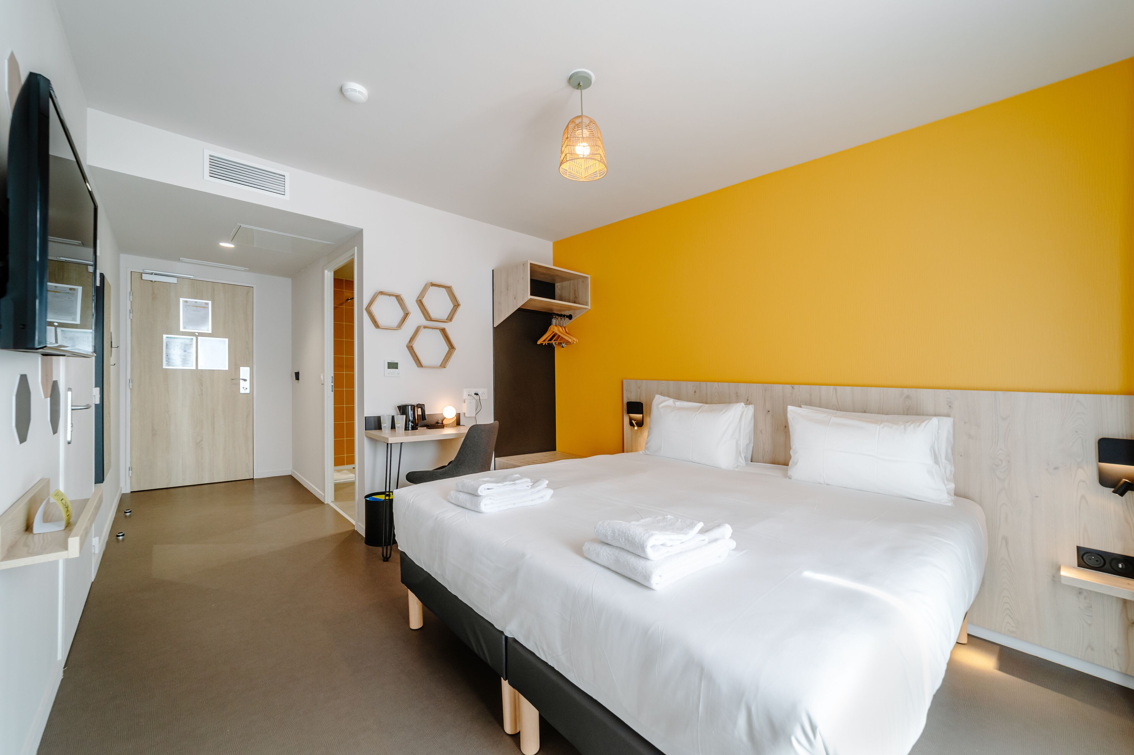 Een moderne hotelkamer met een groot bed, een bureau en een zithoek.