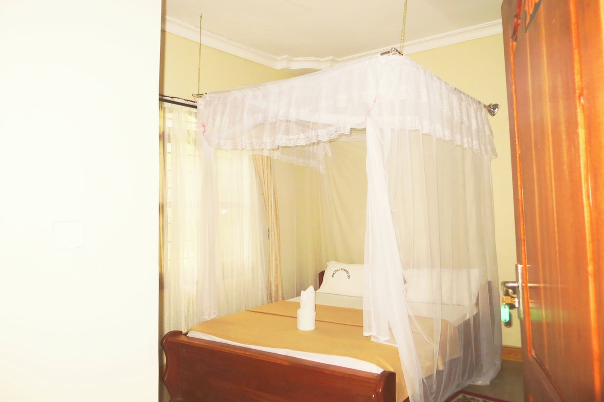 A single bed with a canopy, a bedside table, and a nightstand.