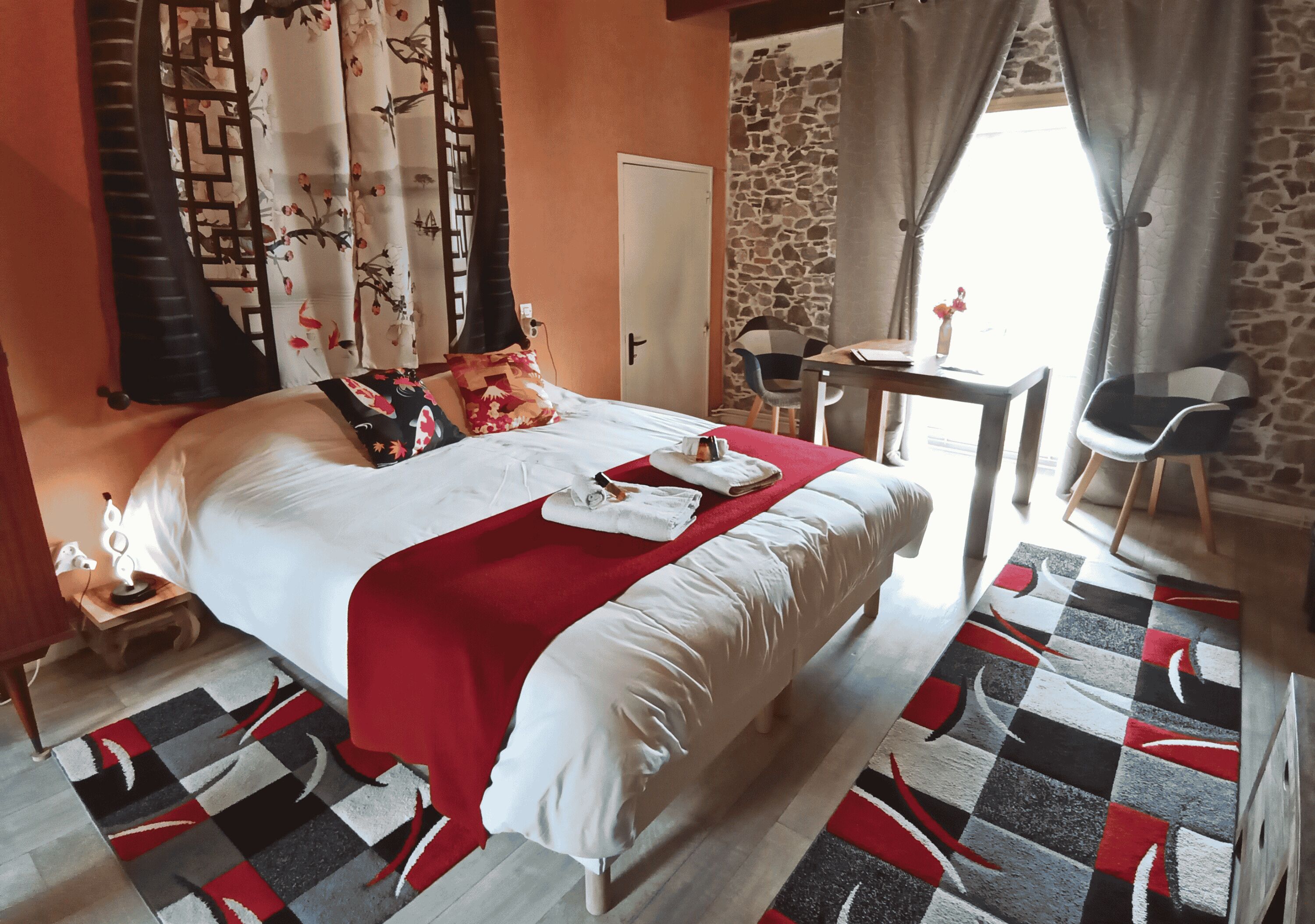 Une chambre d’hôtel avec un lit, un bureau, une chaise et une vue sur l’extérieur.