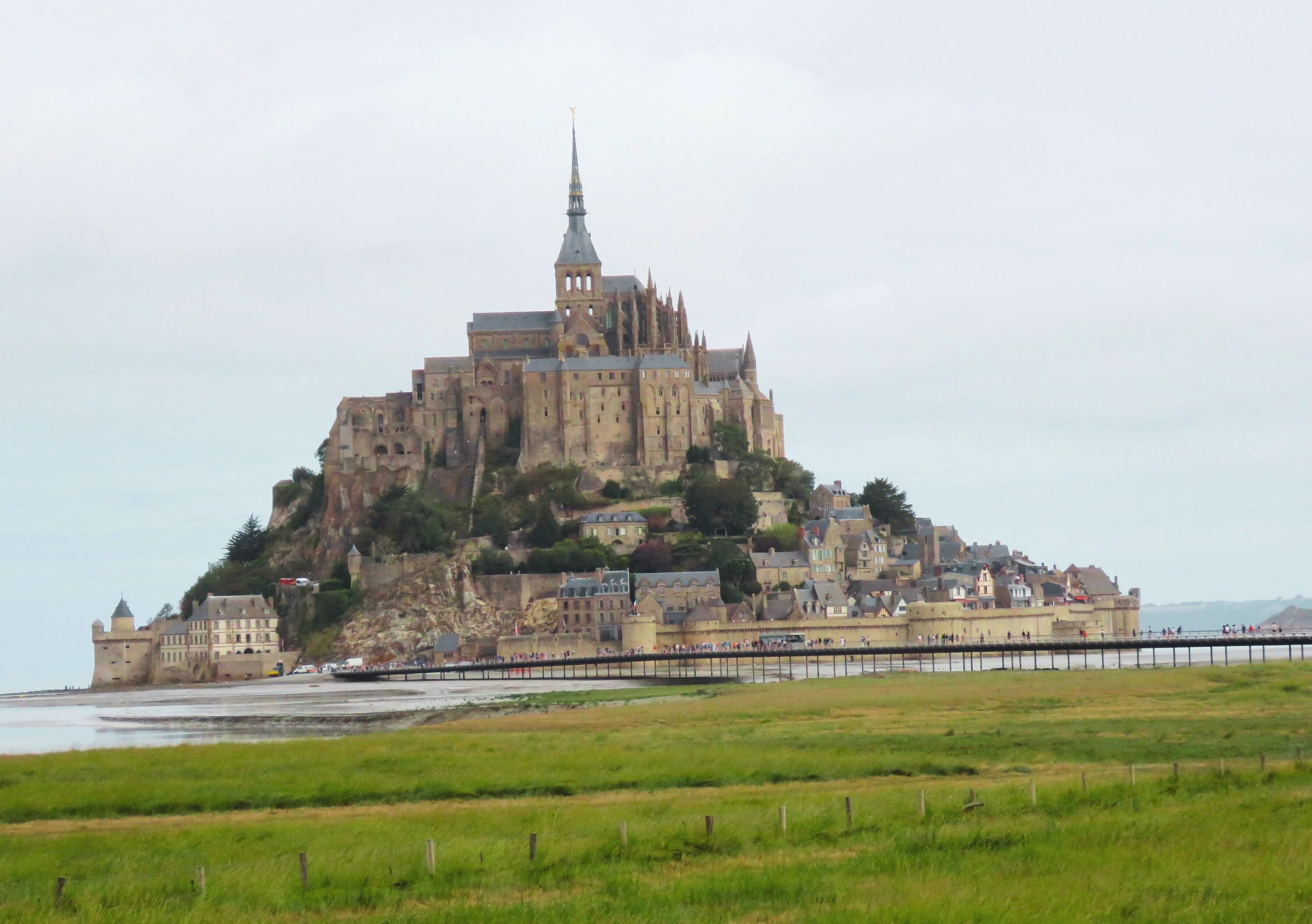 A historic castle on a hill overlooking a coastal area.