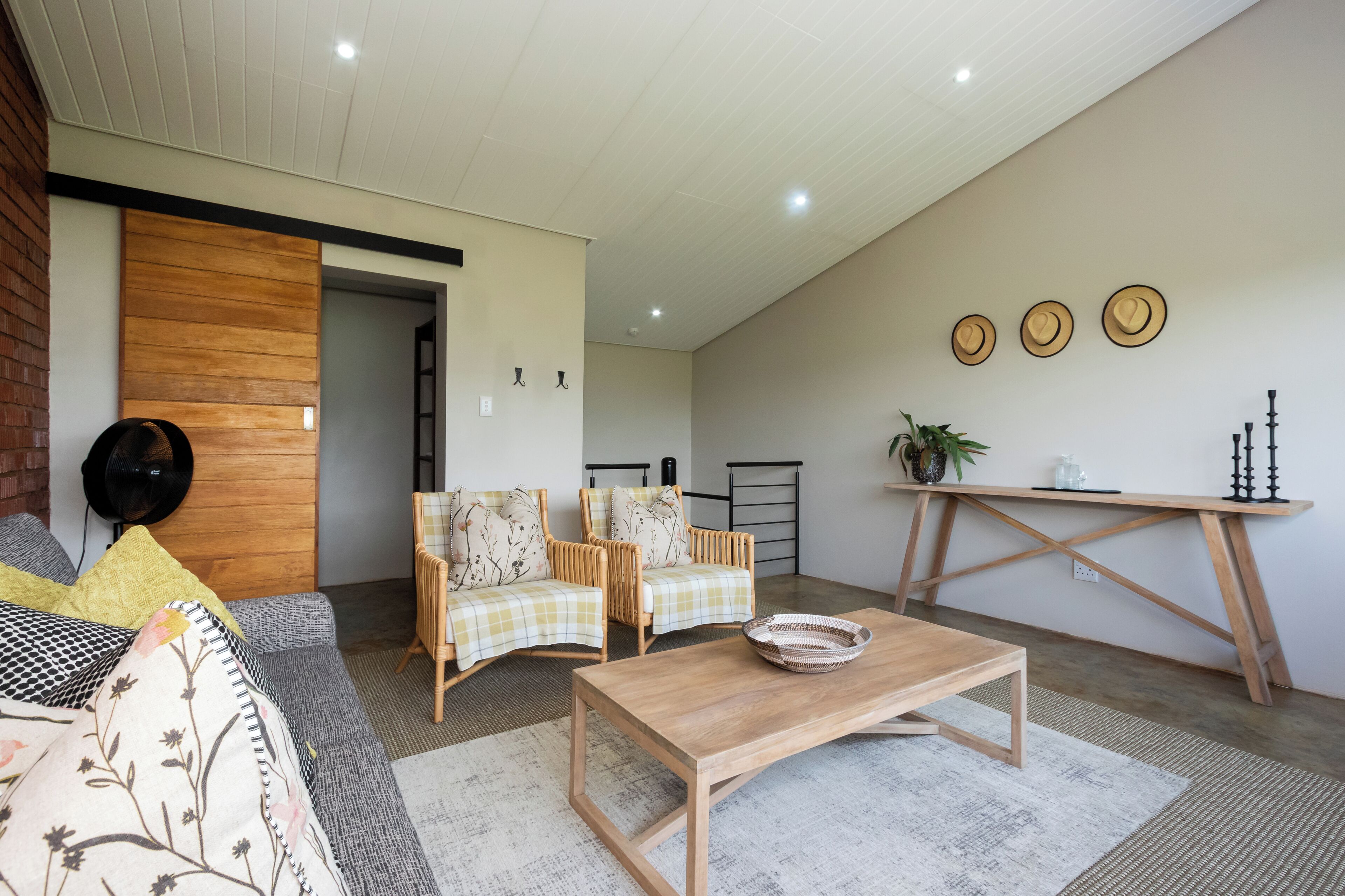 Uma sala de estar moderna com um sofá, duas poltronas, uma mesa de centro e uma mesa de jantar.
