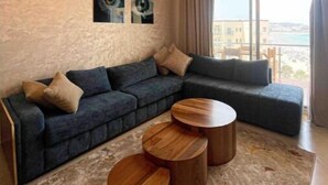 Ein modernes Wohnzimmer mit einem Ecksofa, einem Couchtisch und Blick auf die Stadt.