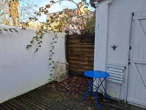 Enjoy a peaceful retreat on the deck with a comfortable chair and a birdcage.