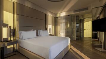 Une chambre d’hôtel moderne dotée d’un grand lit, de tables de chevet, d’un téléviseur à écran plat et d’un miroir.