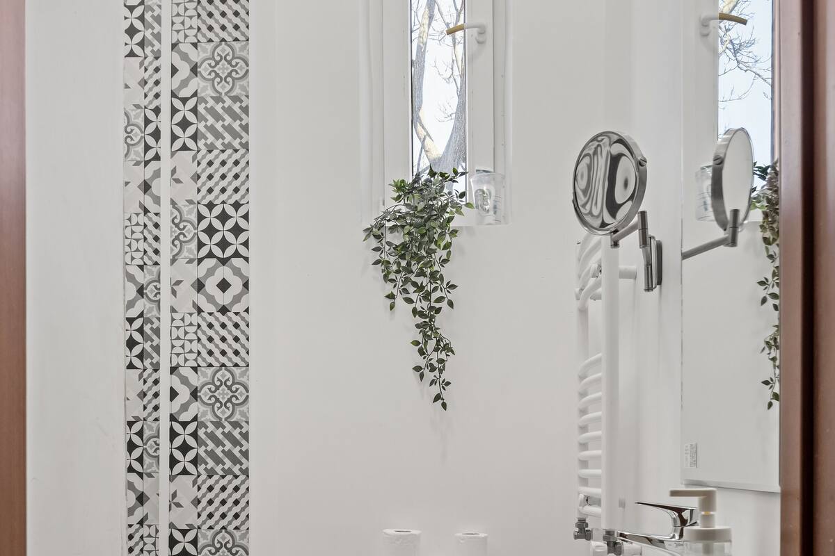 A bathroom with a toilet, sink, and window.