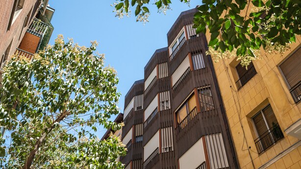 A multi-story building with a modern architectural design, featuring balconies and large windows. - Estudio Encantador Plaza España (Madrid)