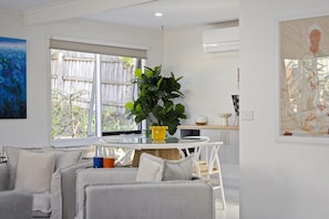 Una sala moderna con un sofá, una mesita de centro y una planta grande.
