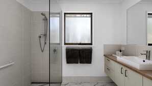 A modern bathroom with a shower, a sink, and a mirror.