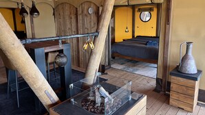 Une chambre rustique avec un lit, des meubles en bois, un luminaire suspendu et une vitrine contenant des fruits à coque.