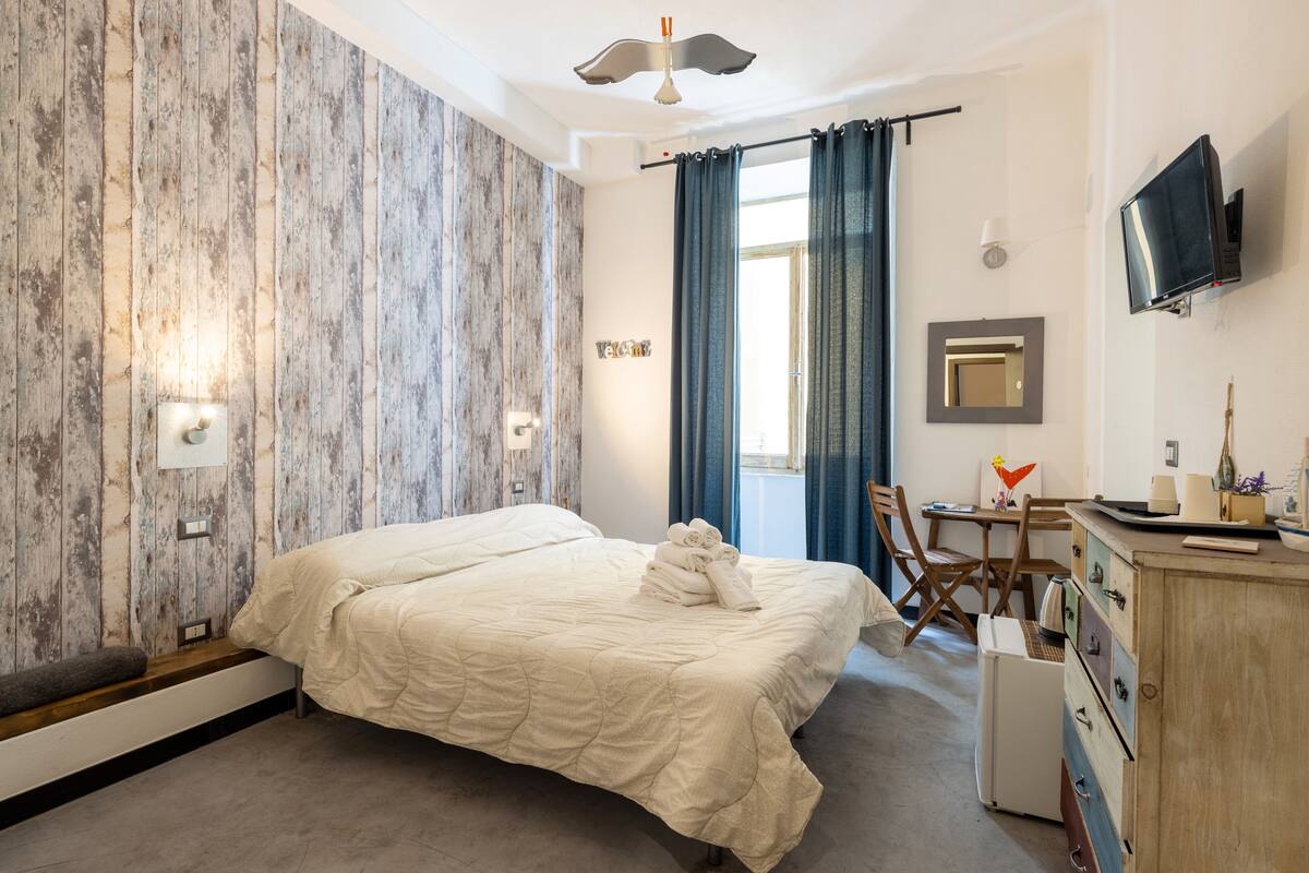 Une chambre d’hôtel équipée d’un lit, d’un bureau, d’une télévision et d’une armoire.