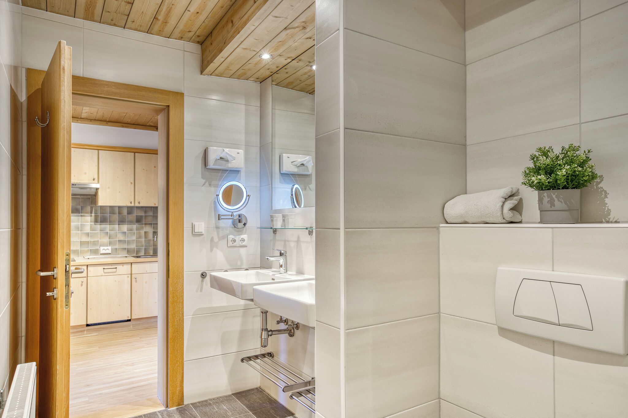 A modern bathroom with a white sink, a mirror, and a towel rack.