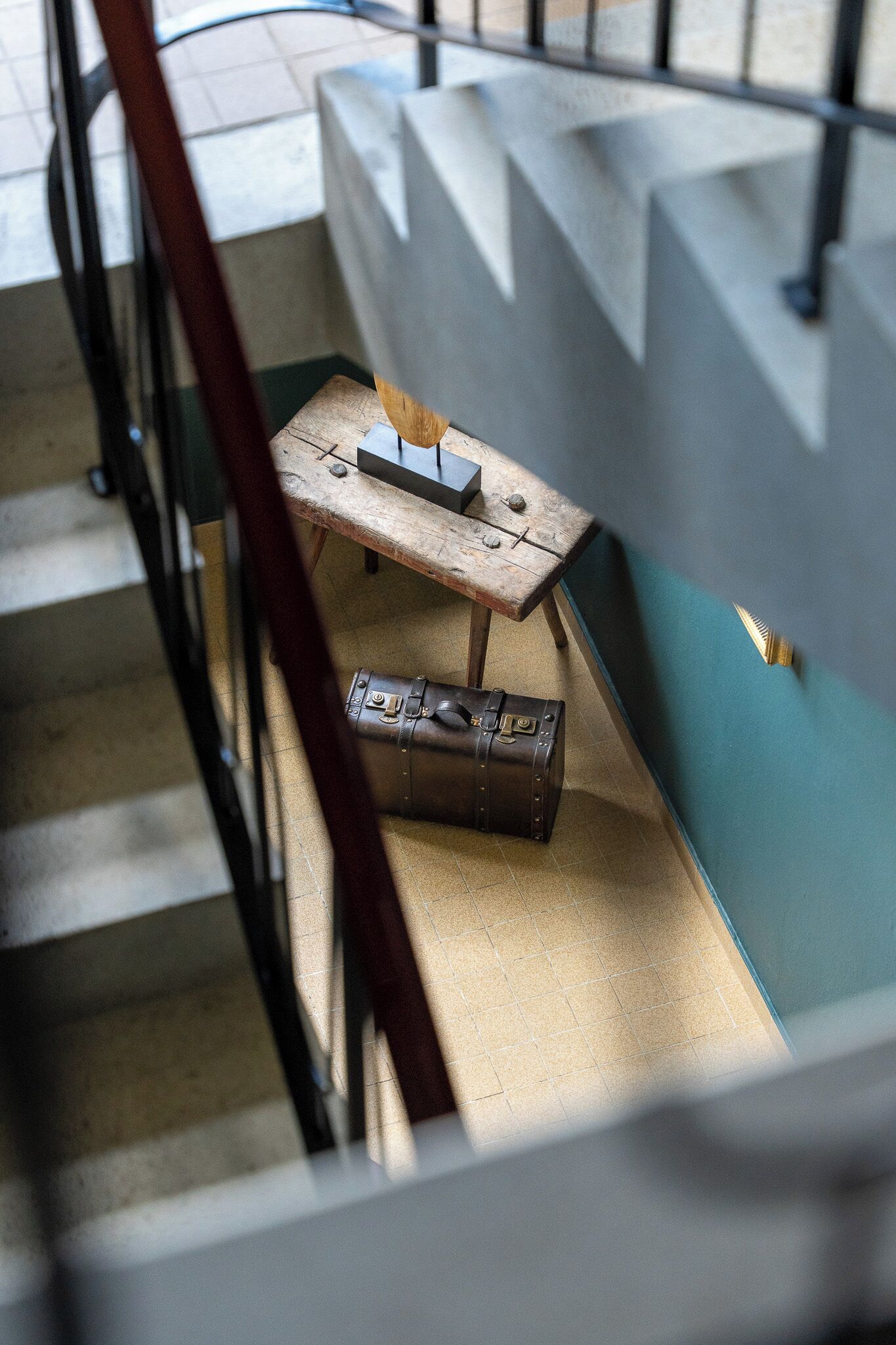 Eine Treppe mit einem Holztisch und einem Koffer.