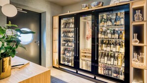 A modern kitchen with a built-in wine fridge, a wooden countertop, and a potted plant. - Boutiquehotel ZOMM in Seefeld (Seefeld in Tirol)