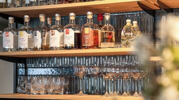 Zona de bar con estantes llenos de botellas de licor y vasos.