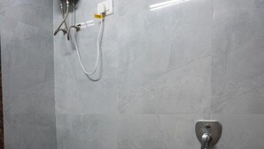A bathroom with a toilet, a bidet, and a trash bin.