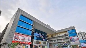 A multi-story commercial building with large glass windows and several storefronts.