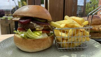 A burger with fries on a plate.