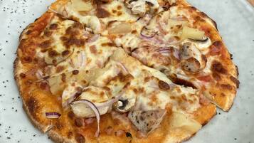 Una pizza con ingredientes sobre un plato blanco.