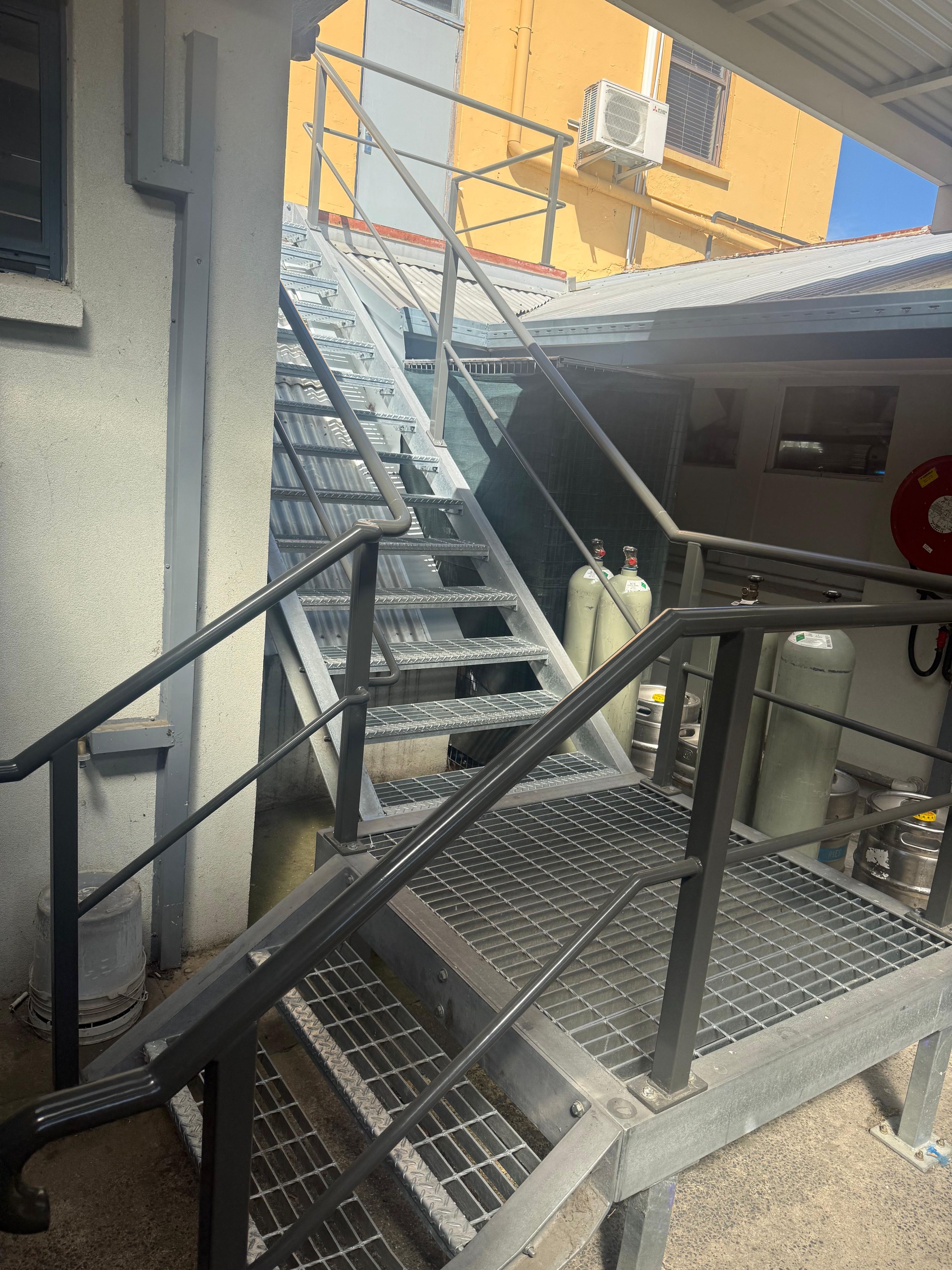 Una escalera metálica con barandillas que lleva a la entrada de un edificio.