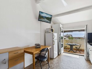 Quarto compacto com cozinha compacta, área de refeições e varanda com vista.