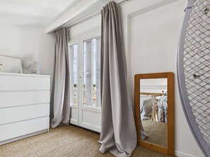A bedroom with a white dresser, a mirror, and a view of the outside. - Cozy Mezzanine Studio 250m from Beach, Pet-Friendly, Sleeps 4 (Le Grau d'Agde)