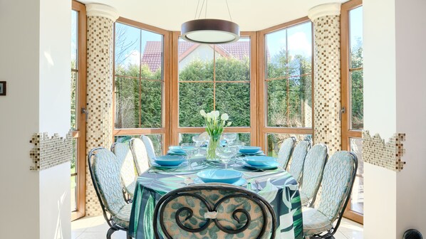 Enjoy meals with friends and family at this spacious dining area, featuring a large round table and six comfortable chairs.