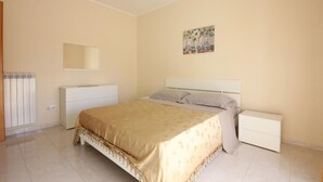 A bedroom with a bed, bedside tables, a radiator, a mirror, and a painting on the wall. - 1 bedroom beautiful apartment in Parco dei Tigli (Parco dei Tigli)