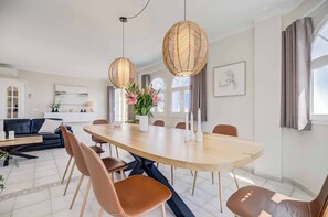 A modern dining area with a round table, brown chairs, and two hanging light fixtures. - 108. Excellent Villa With Heated Pool in Costa del Sol (MIJAS)