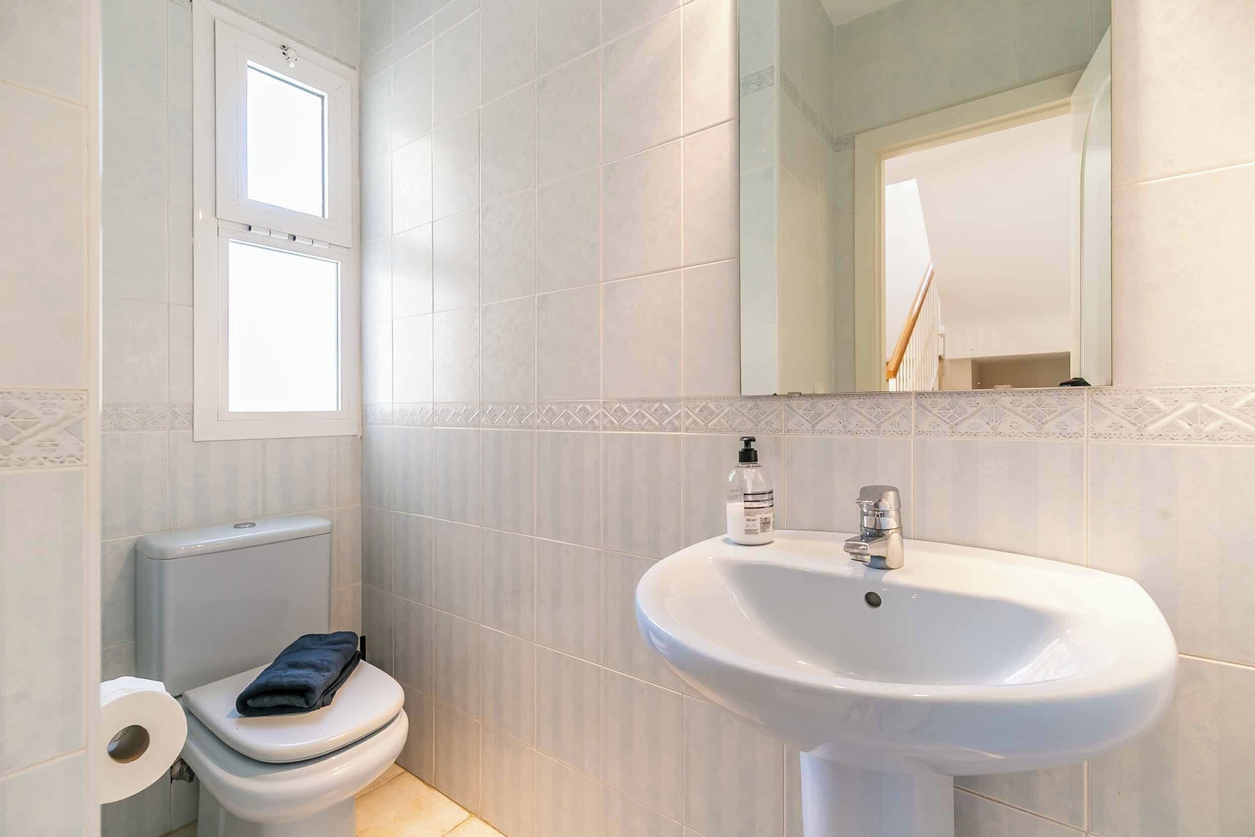 Ein Badezimmer mit Toilette, Waschbecken und Spiegel.