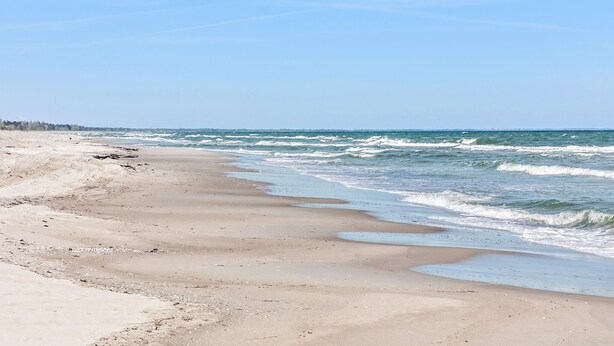 A beach with a sandy shore and waves crashing onto it. - Nice home in Gedser with kitchen (Gedser)