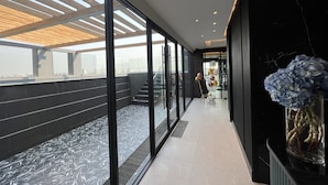 A modern interior with a glass corridor, a staircase, and a view of the cityscape. - ARNI Skye Hotel (Bangkok)
