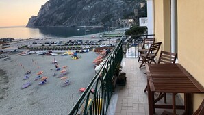 Un balcon avec vue sur une plage et une montagne.
