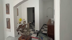 A room with a checkered floor, a marble countertop, and several framed pictures on the wall. - Bouganville House in the center - amazing sea view (Monterosso al Mare)