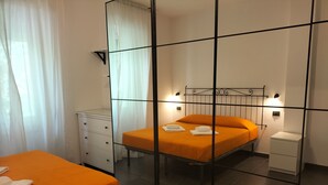 A bedroom with an orange bed, a white dresser, a mirror, and a nightstand.