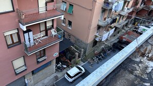 A multi-story residential building with balconies, a street in front, and parked vehicles. - Delfino Cosy Apartment With A/C  Near best bea... (Monterosso al Mare)
