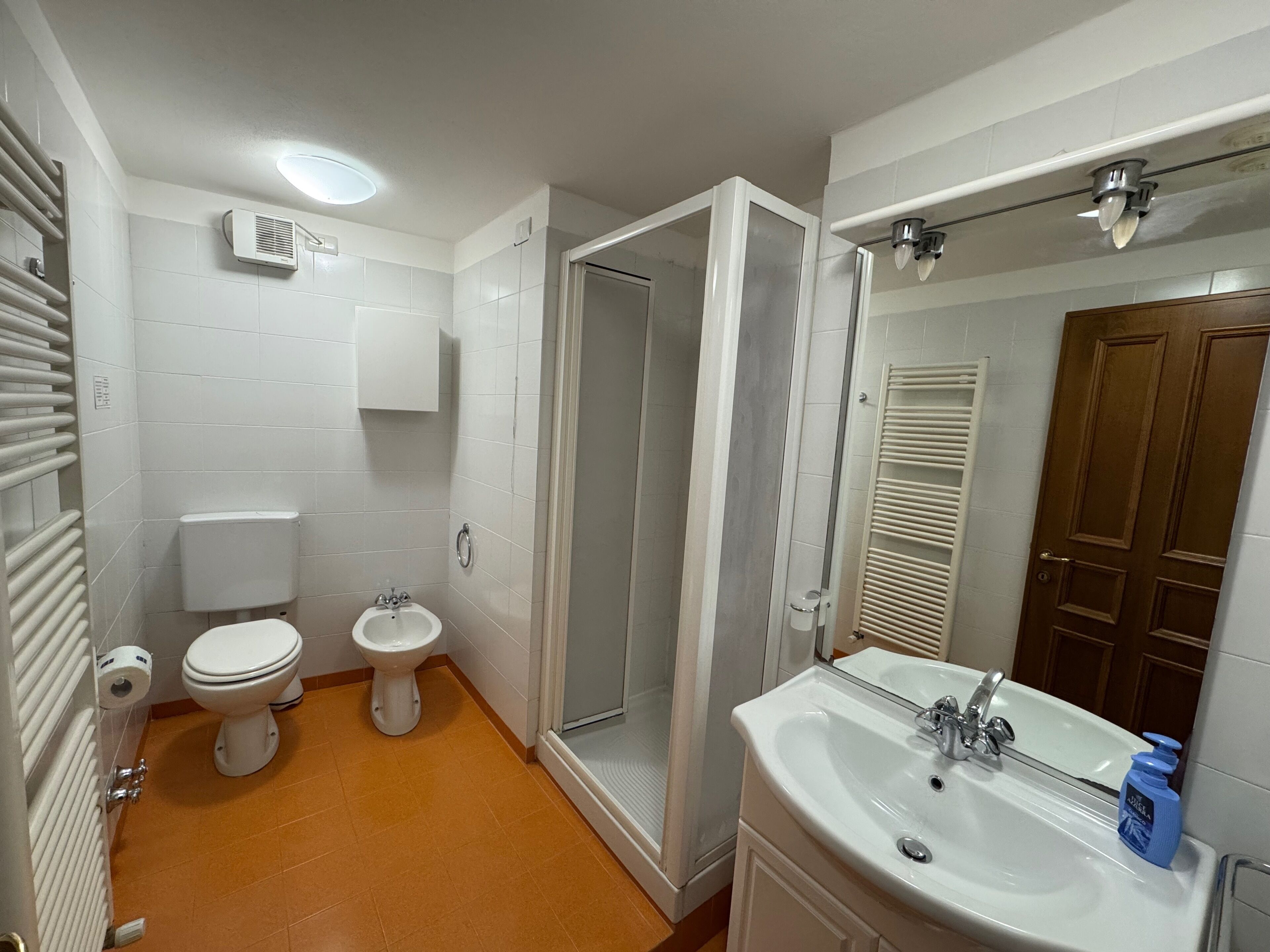 Ein Badezimmer mit Toilette, Bidet und Duschkabine.