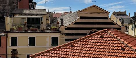 Un bâtiment doté d’un toit triangulaire et d’un balcon orné de plantes en pot.