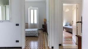 Habitación de hotel con piso a cuadros, una cama con colcha estampada, un escritorio con lámpara y un televisor.