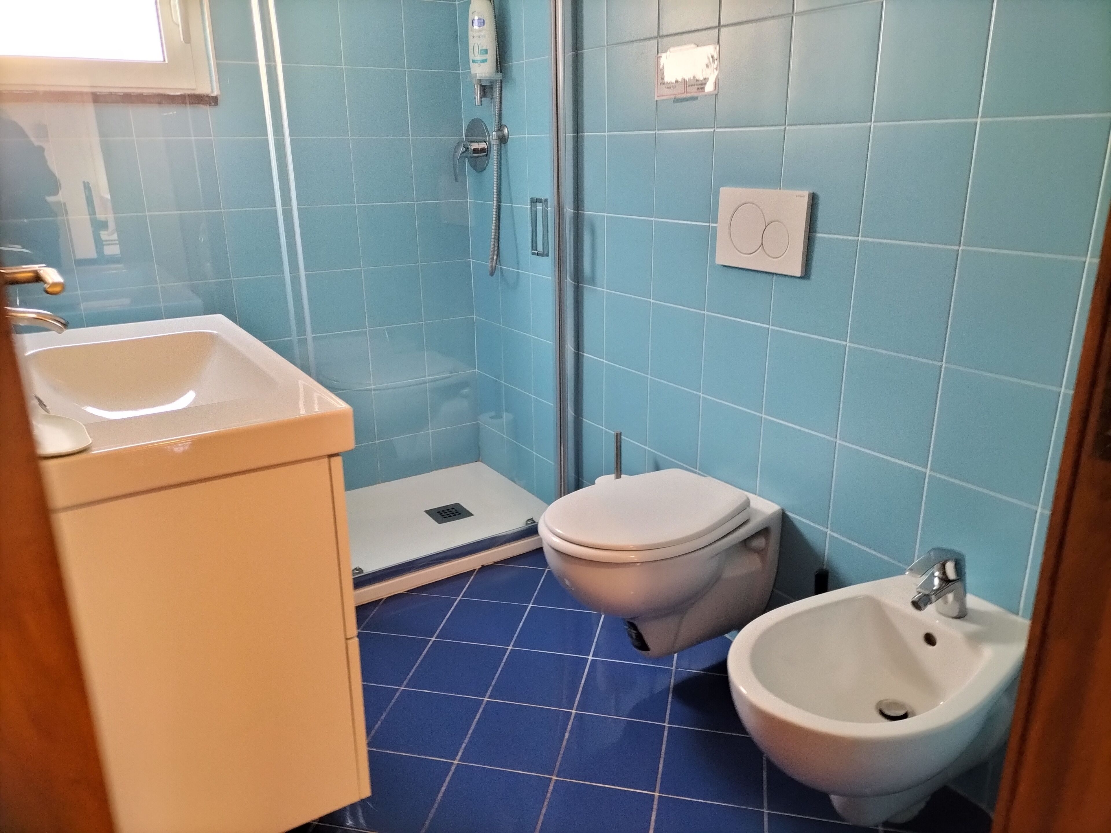 Et badeværelse med toilet, bidet og håndvask.