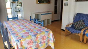 Ein Zimmer mit einem Bett, einem Schreibtisch, einem Stuhl und einem Regal mit verschiedenen Gegenständen.