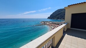 Ein Balkon mit Blick auf einen Strand und das Meer.